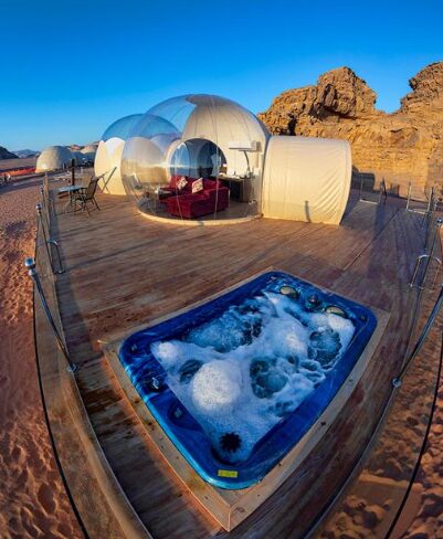 Transparent bubble dome suites with a private hot tub on a wooden deck in Wadi Rum